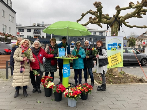 Fairtrade Steuerungsgruppe 2025 Die Mitglieder der FairTrade Steuerungsgruppe stehen vor einem Infostand im Engelskirchener Ortskern mit Blumen © Fairtrade Steuerungsgruppe Engelskirchen