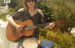 Gisela auf Mauer mit Gitarre und Bongos.jpg